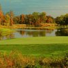A view of green with water in background at Far Oaks Golf Club