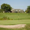 A view of green with clubhouse in background at Hickory Point Golf Course