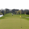 A view of green at Bittersweet Golf Club with water on one side and golf cart in background