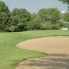 A view of green surrounded by bunkers at Village Green Country Club